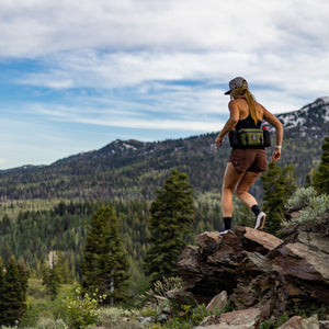Woman running in the mountains with park pack