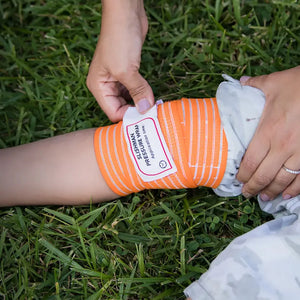 A person applying a slishman pressure wrap