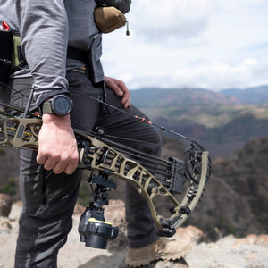 Man hunting with a bow, wearing a garmin watch