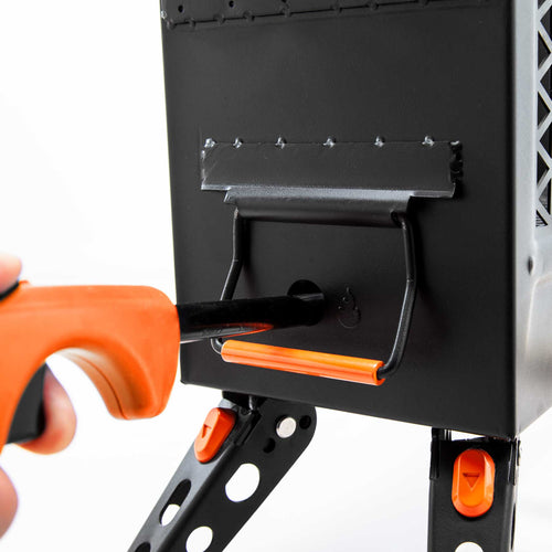 Ignik Outdoors FireCan Fire Pit, a black portable camping fire pit, being lit by an orange lighter