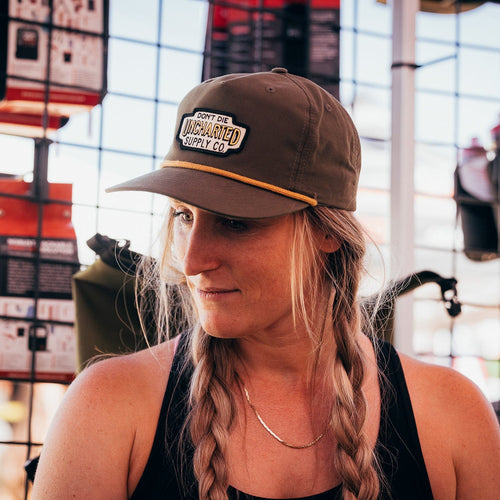 Rover Hat green & gold with yellow rope, 'Don't Die Uncharted Supply Co' patch on woman