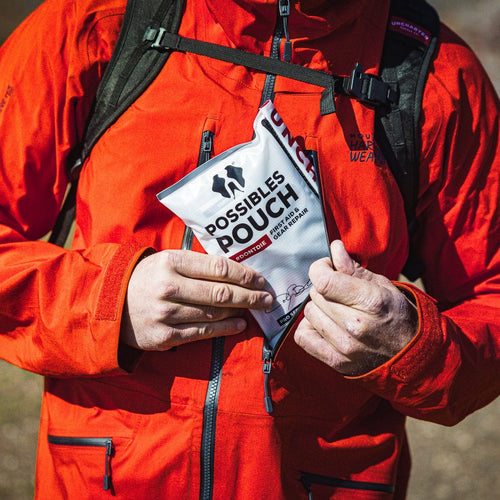 Person in a red jacket holding a possibles pouch