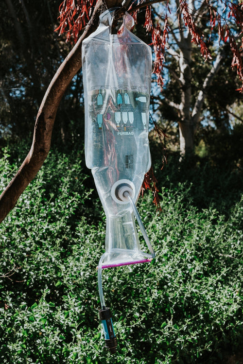 Puribag Pro System outdoor water purification system hanging from a tree