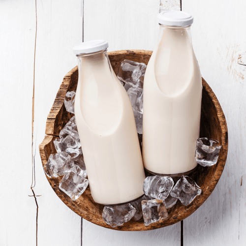 One Month Food Supply: ReadyPantry, two chilled milk-like beverages in glass bottles with ice in a rustic wooden bowl