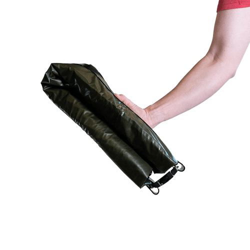 photo of a mans arm holding a packed rapid raft showing it to be roughly the size of a loaf of bread