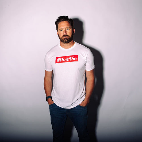 The Hashtag t-shirt, a man modeling white #DontDie survival apparel from Uncharted Supply Company