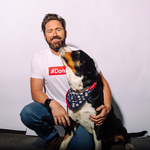 The Hashtag white t-shirt on smiling man with dog licking his beard, red #Don text