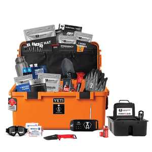 An open orange Basecamp 60L survival kit with various supplies and equipment organized inside, including food, tools, and emergency gear.