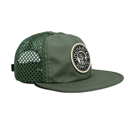 Olive green Trailblazer Performance Hat with a mesh back, flat brim, and round Uncharted Supply Co dog logo patch