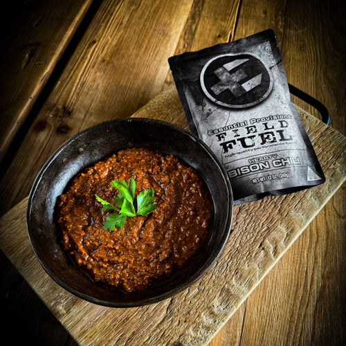 Ready-to-Eat BISON CHILI, Essential Provisions camping meal in a bowl with a pouch on rustic wood