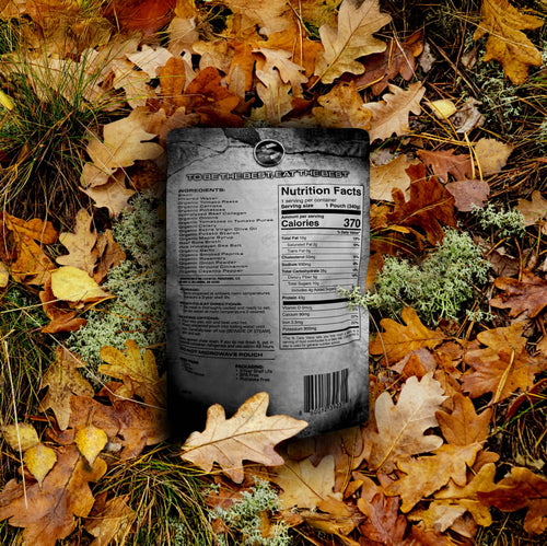 Bison stew ready-to-eat meal pouch by Essential Provisions on a forest floor with fallen leaves