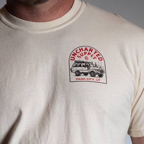 Death Avoidance Specialist T-Shirt, off-white, worn by person, features Uncharted Supply Co. off-road vehicle graphic