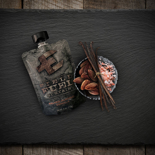 Essential Provisions Sustain Salted Almond Vanilla energy blend pouch with almonds, vanilla beans, and pink salt on slate