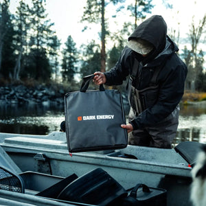 Dark Energy 56W Spectre Accessories Kit, black portable power kit held by angler in a boat