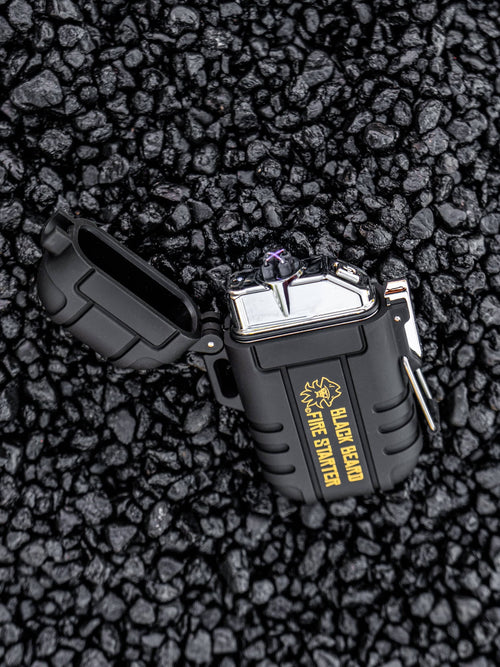 Grab & Go Fire Starter Kit, Black Beard waterproof plasma lighter open and sparking on dark rocks