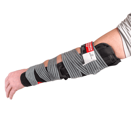 Slishman Pressure Wrap on an arm, grey elastic wound over black pad, for emergency first aid