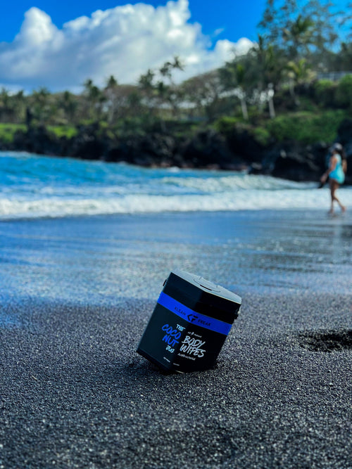 Body Wipes - The Jug by Klean Freak on a black sand beach with ocean and person in background