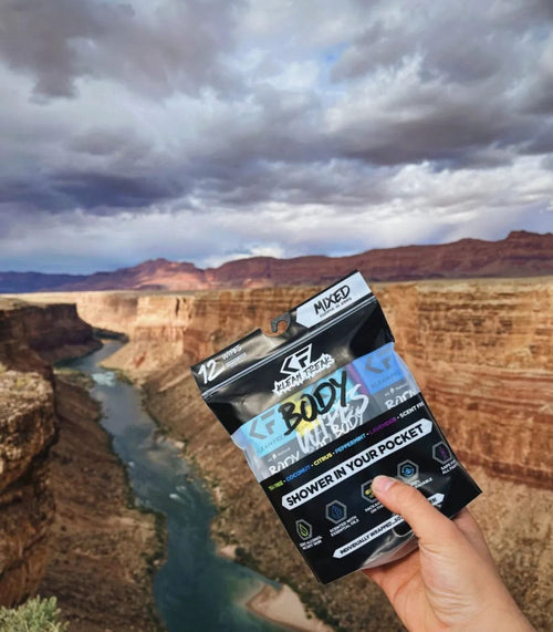 Klean Freak Body Wipes - 12 pack for outdoor adventure, 'shower in your pocket' wipes held above a canyon