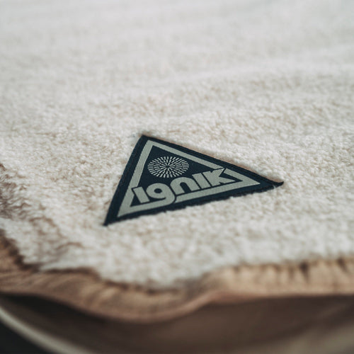 Flipside Heated Bed Cover Fleece close-up of soft cream fleece with Ignik Outdoors triangle logo patch