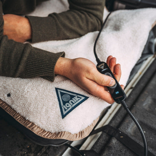 Ignik Flipside Heated Bed Cover Fleece: person using a soft beige heated blanket with controller