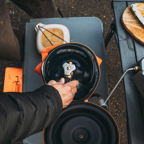 Ignik Outdoors Gas Growler 3.8 Deluxe connected to camping stove for outdoor cooking