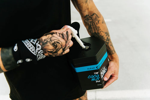 Klean Freak Body Wipes - The Jug, person pulling an antimicrobial wet wipe from the black hexagonal container