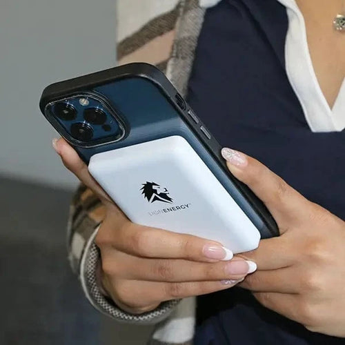 Lion Claw magnetic wireless power bank, a white Lion Energy phone charger attached to a blue smartphone in a person's hands
