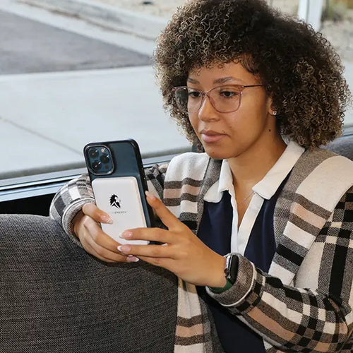 Lion Claw magnetic portable phone charger by Lion Energy Staging shown on phone held by a woman