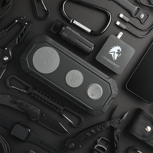 Lion Eclipse Mag multi-device wireless power bank, a rugged portable charger shown with tactical EDC and outdoor gear