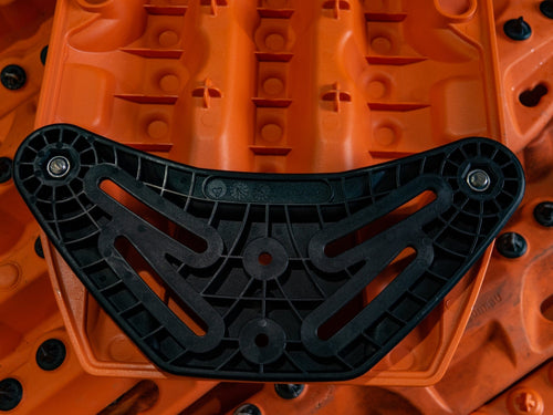 MAXTRAX Flat Rack Mount, black plastic bracket on orange recovery board, secured by bolts