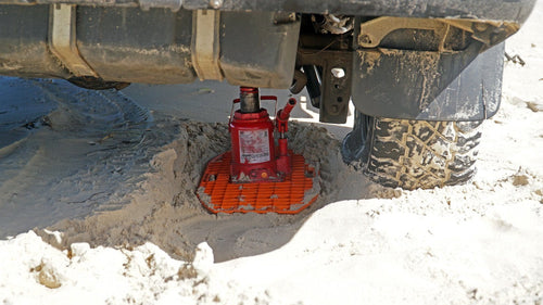 MAXTRAX JaxBase Combo by Adventure Imports supporting a red bottle jack lifting a vehicle in sand