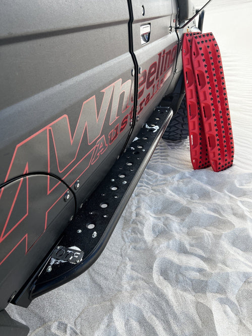 Adventure Imports MAXTRAX XTREME Red Recovery Boards mounted on a dark off-road vehicle on sand for traction