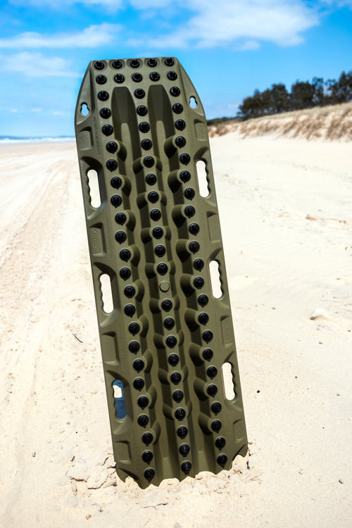 MAXTRAX Xtreme Olive Drab Recovery Boards with black grip lugs, standing vertically in beach sand