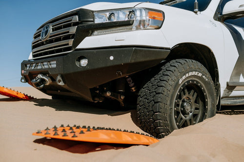 MAXTRAX XTREME Signature Orange Recovery Boards by Adventure Imports assisting a white truck stuck in sand