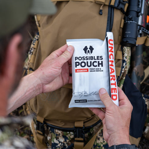 Person holding a 'Possibles Pouch' first aid and gear repair kit with 'Uncharted' branding.