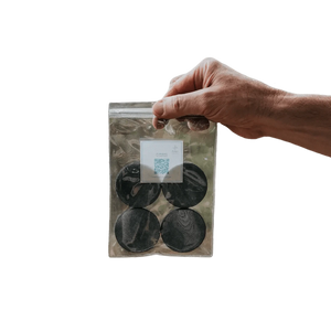 Puribag Filter Replacement Pack: hand holding clear bag with four round black water filter refills
