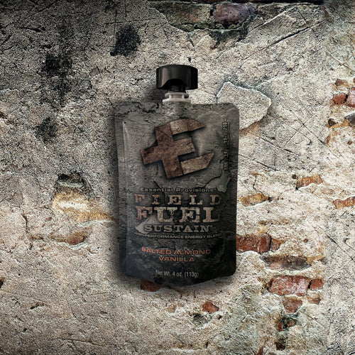 Essential Provisions FIELD FUEL Sustain energy blend salted almond vanilla pouch on a rough concrete and brick wall