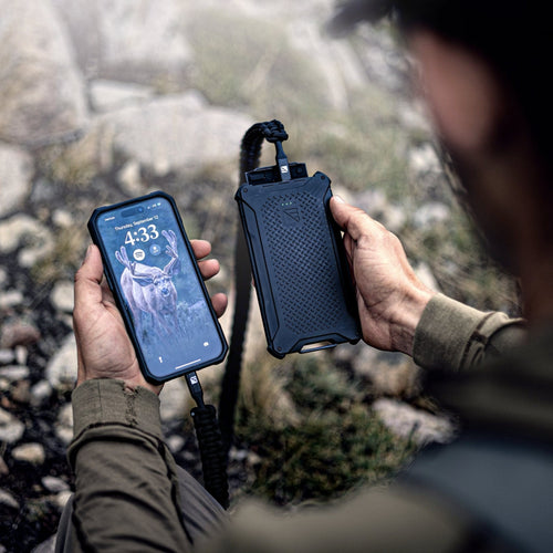 Poseidon Pro by Dark Energy, a rugged black power bank charging a smartphone in a person's hand outdoors