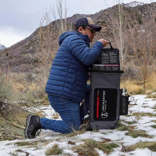Person in a blue jacket and cap pulling seventy2 insert out of the backpack shell