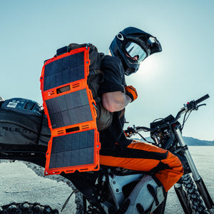 Dark Energy Spectre 18W orange & black solar panel for adventure, on backpack while dirt biking