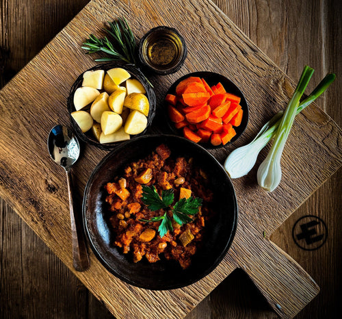 Essential Provisions Ready-to-Eat Meal in a bowl with carrots, potatoes, rosemary, green onions on wood