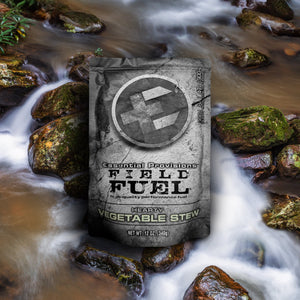 Essential Provisions Field Fuel Vegetable Stew ready-to-eat meal pouch on a mossy rock by a flowing stream