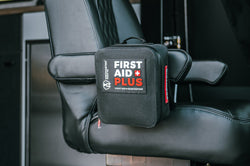 Uncharted Supply Co First Aid Plus + gear repair kit on a black leather seat in a vehicle