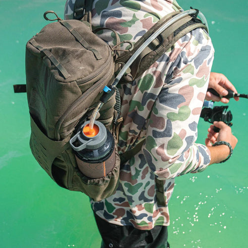 Hardside Hydration SWIG RIG - WIDE MOUTH hydration tube in a water bottle on a backpack. Angler in camo shirt fishing