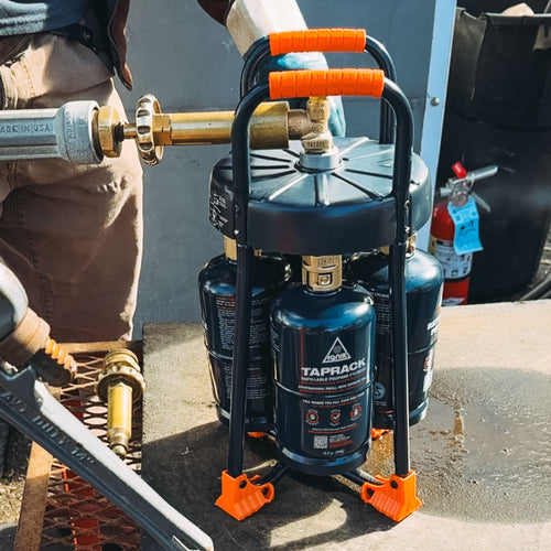 Ignik TapRack Refillable Propane System being connected for refilling small cylinders, shown in use
