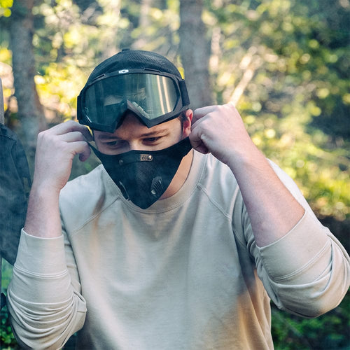 Air Filtration Mask by RZ Mask, black tactical mask with dual vents, worn by a man adjusting it outdoors