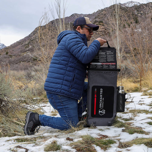Person in a blue jacket and cap pulling seventy2 insert out of the backpack shell