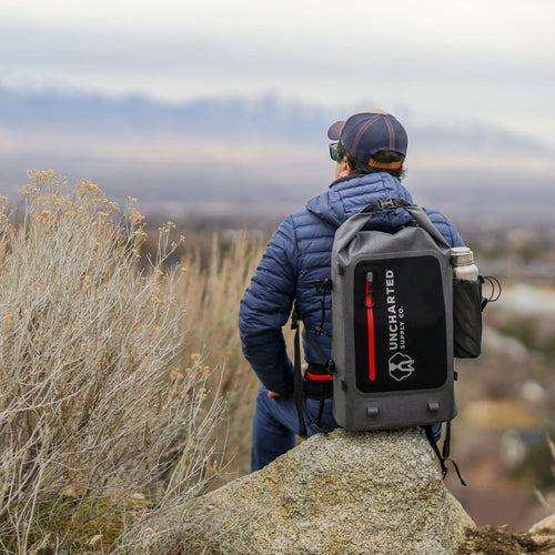 Person sitting on a rock with the seventy2 shell on their back