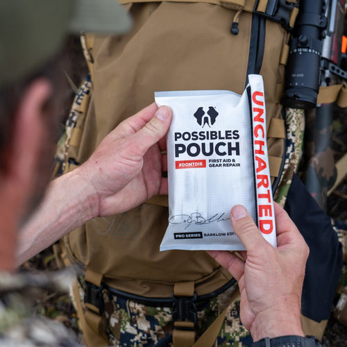 Person holding a 'Possibles Pouch' first aid and gear repair kit with 'Uncharted' branding.