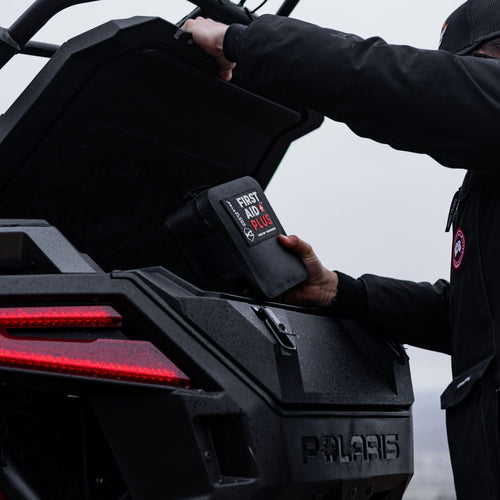 person taking first aid plus out of the back of a UTV